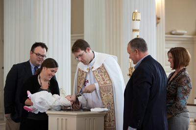 Infant being baptized with parents, godparents, priest
